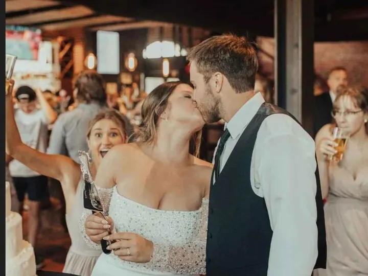 Newlyweds kissing while cutting their wedding cake