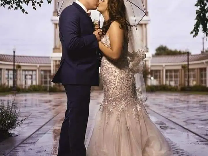 Wedding couple kissing beneath a clear umbrella