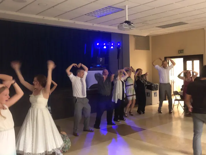 Guests participating in a group dance at a reception
